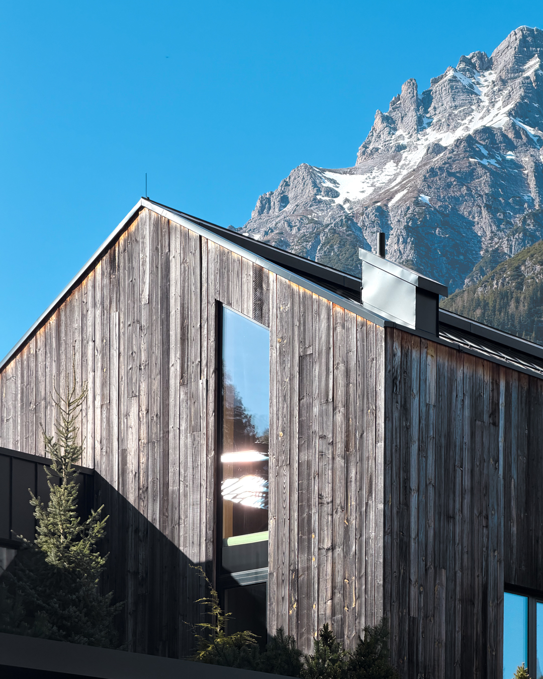 Esempio di architettura sostenibile con materiali locali e progettazione integrata in dialogo con il paesaggio naturale circostante
