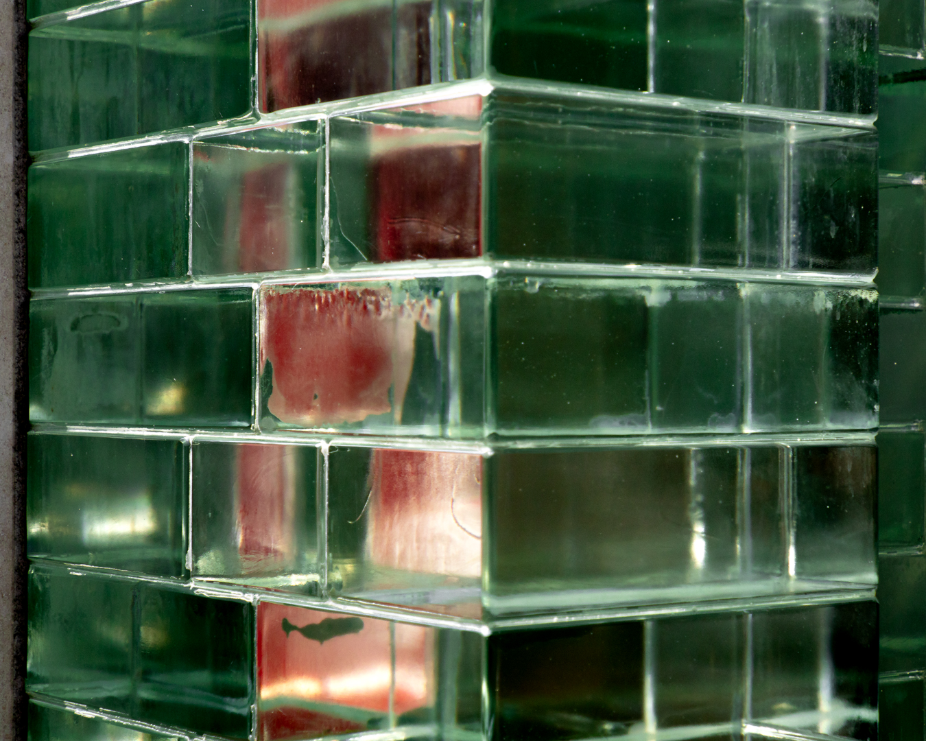 Dettaglio costruttivo del passaggio tra mattoni di vetro e mattoni terracotta nella facciata di Crystal Houses