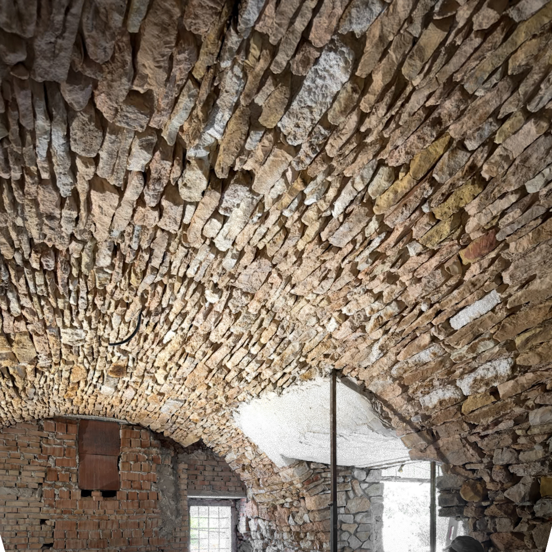 Dettaglio di pietra a vista in un rustico restaurato, valorizzazione della muratura originale come scelta di progettazione architettonica e interior design.