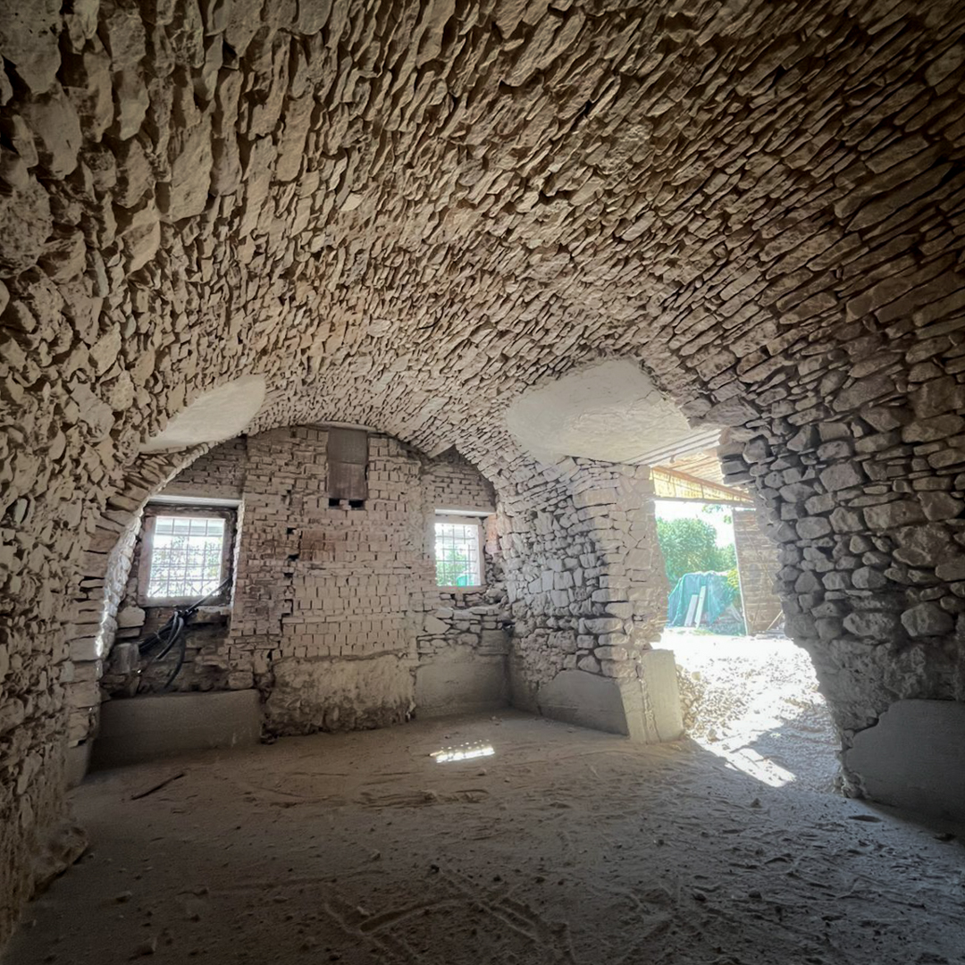 Muratura storica durante la pulitura con sabbiatura a secco, fase di recupero conservativo che riporta a vista la pietra originale dell'edificio.