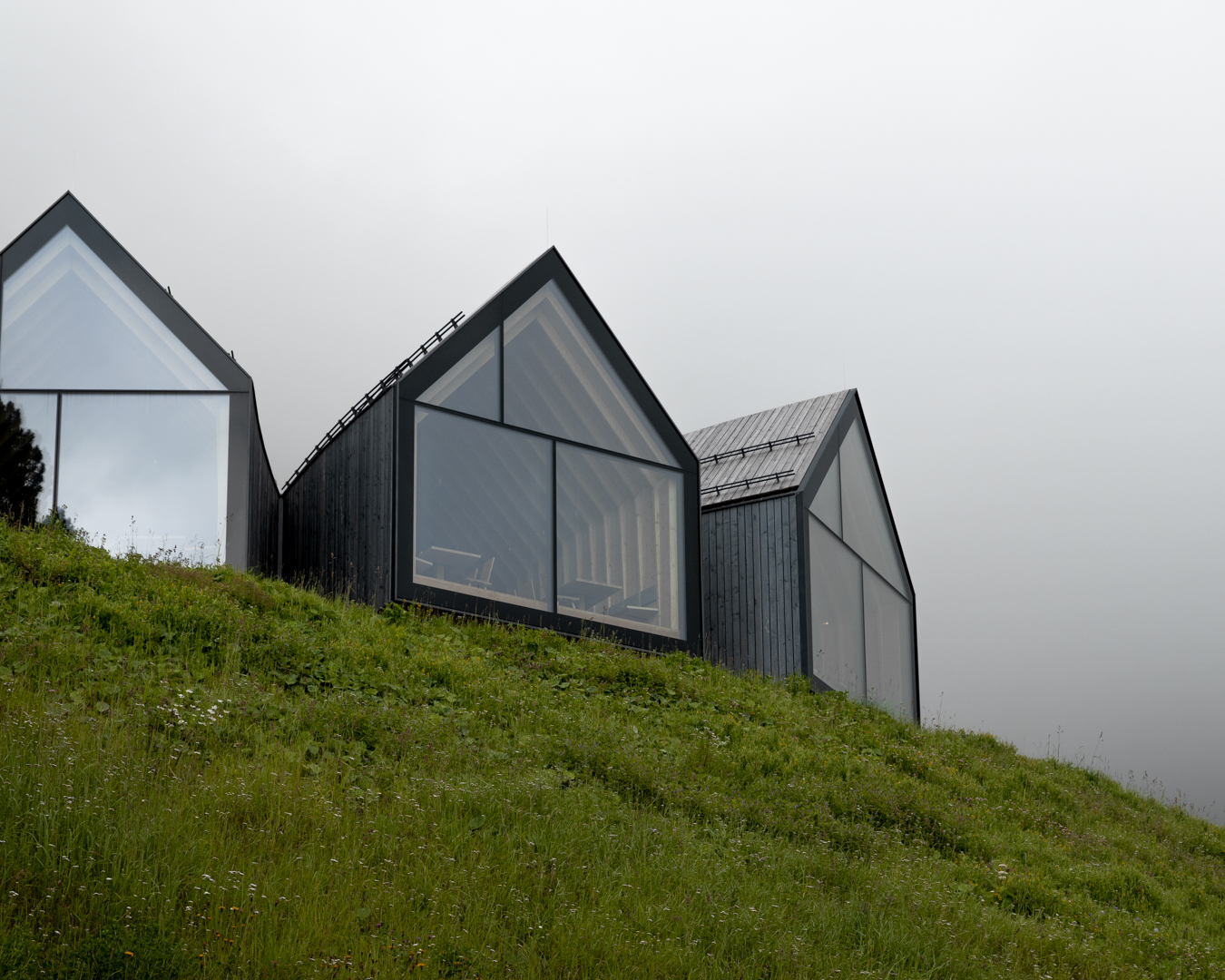 Struttura in legno a sbalzo di un rifugio di montagna, dove il volume si protende verso valle integrando architettura e progettazione strutturale