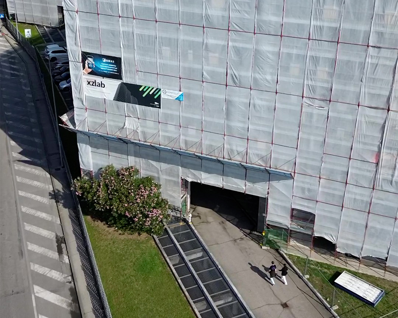 Posa delle lastre in gres sulla nuova facciata di un edificio a torre, lavorazione in quota durante il cantiere di riqualificazione edilizia
