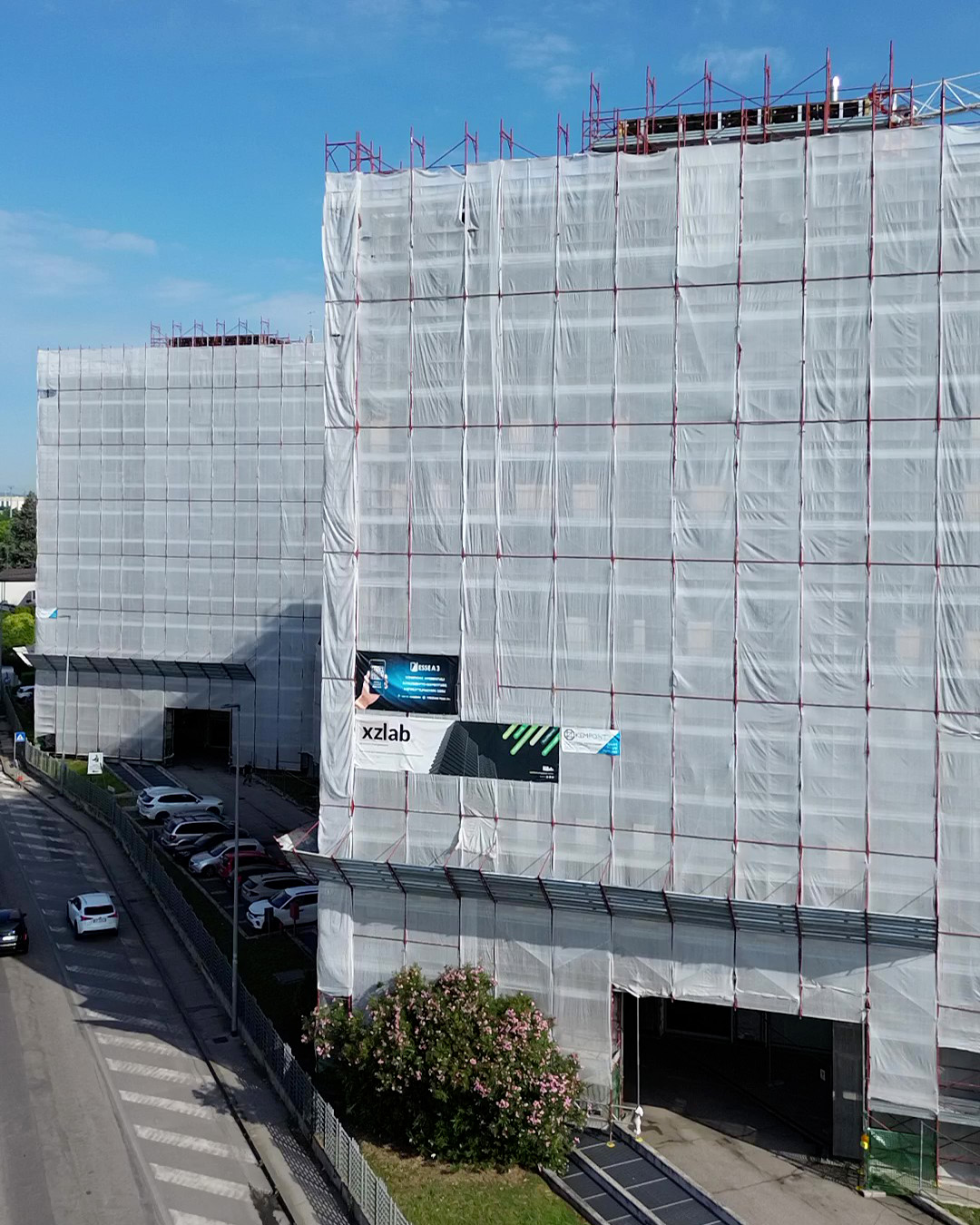 Direzione lavori in cantiere sulla facciata di un edificio esistente, verifica dei dettagli di posa del rivestimento in gres con le maestranze